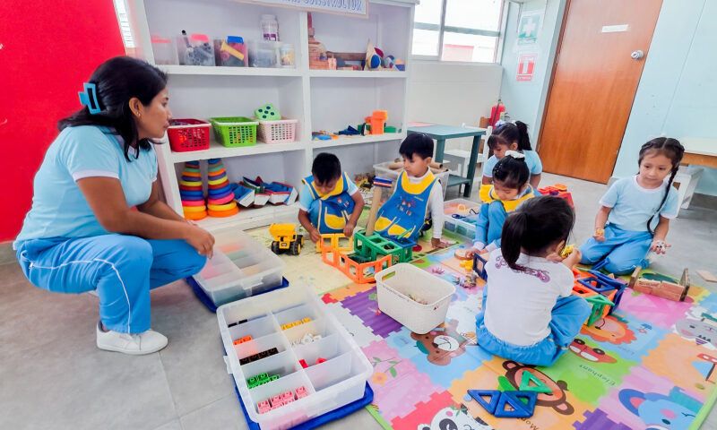 Banner institucional por el Día de la Educación Inicial con docente y niña compartiendo juego educativo..