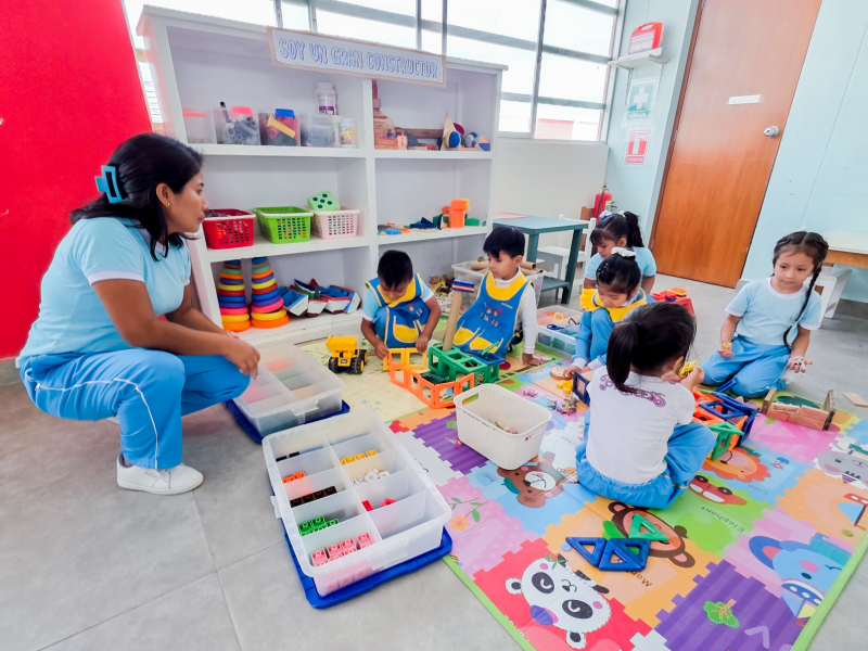 Banner institucional por el Día de la Educación Inicial con docente y niña compartiendo juego educativo..
