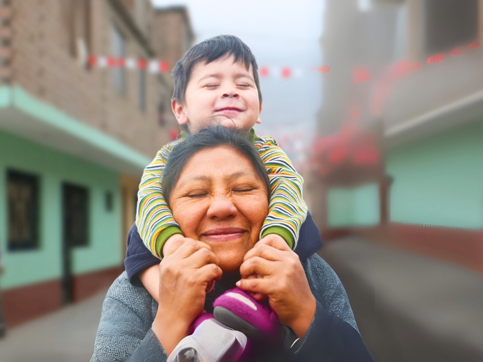  Niño sonriente abrazando a su abuela en comunidad altoandina, símbolo del impacto de Prisma ONG en la calidad de vida familiar.