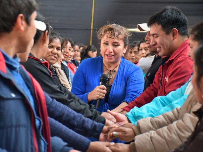 Facilitadora de Prisma ONG conduce dinámica participativa con líderes comunitarios en taller de fortalecimiento de capacidades.