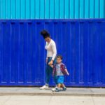 Kimberly y su hijo Matías caminando juntos por la vereda en Trujillo, Perú Prisma ONG