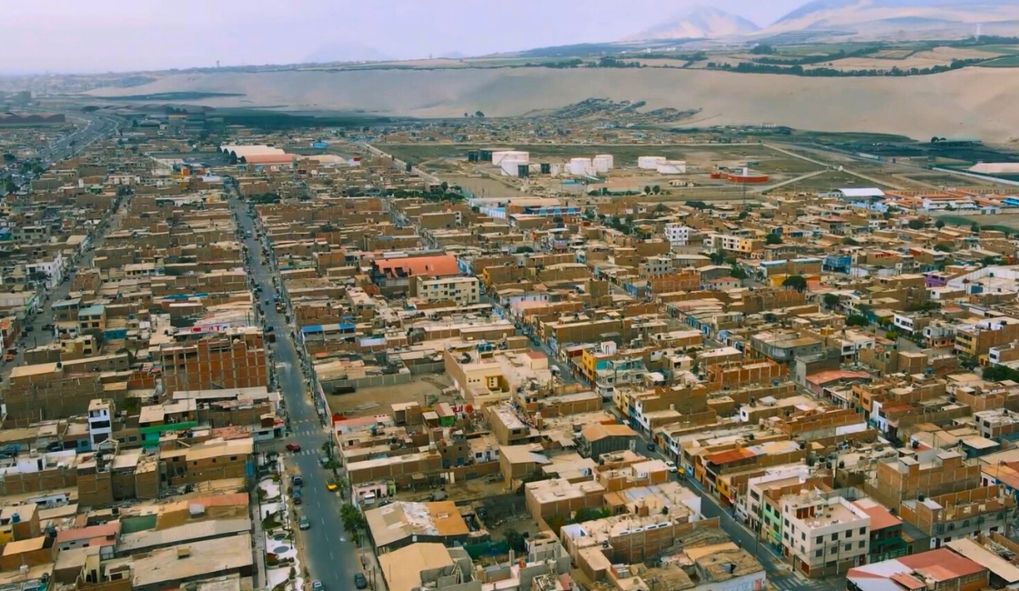 Retrato de Kimberly, mujer venezolana migrante, frente a una pared verde en Trujillo